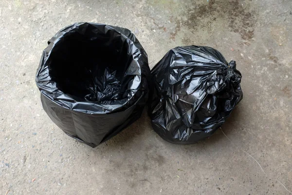 Lata Lixo Com Sacos Plástico Preto Isolado Chão Cimento Background — Fotografia de Stock