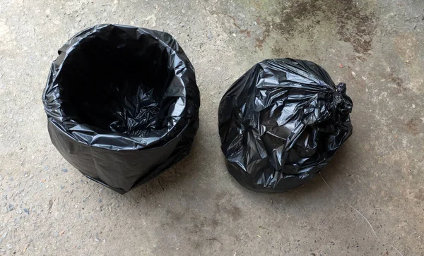 Lata Lixo Com Sacos Plástico Preto Isolado Chão Cimento Background — Fotografia de Stock