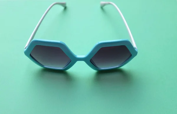 Fechar Azul Pentágono Forma Óculos Sol Isolar Fundo Pastel Verde — Fotografia de Stock