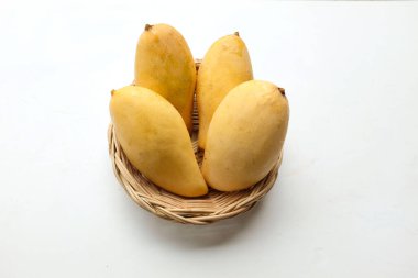 olgun sarı mango, sarı mango, sarı mango, altın nam dok mai mango, barakuda mango (mangifera indica) beyaz arka planda izole edilmiş bambu sepetinin içindeki meyvelerin kralı.