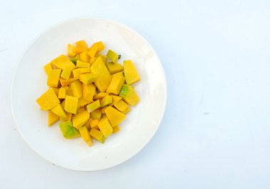 Beyaz arka planda izole edilmiş beyaz bir tabakta dilimlenmiş çiğ kabak, yiyecek hazırla.