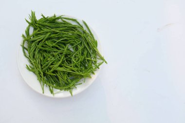 Dilimlenmiş taze yeşil Tırmanan Gıdaklama (Acacia Pennata) beyaz bir plaka içinde izole edilmiş, yiyecek hazırlayın.