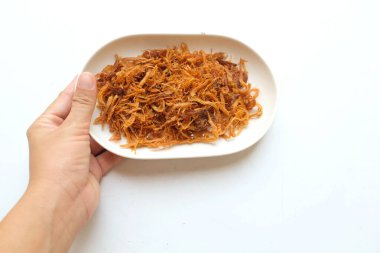 Beyaz arka planda izole edilmiş beyaz seramik tabakta kurumuş domuz eti tutan kadın.