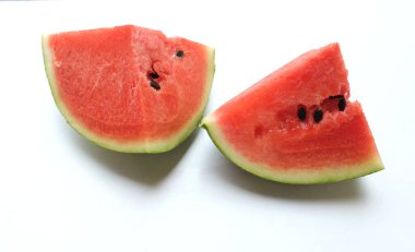 Dilimlenmiş karpuz (Citrullus lanatus) üçgenleri beyaz arka planda izole edilir.