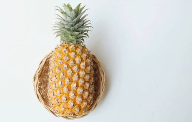 taze bir ananas (ananas comosus (l.) merr) olgun sarı organik bir sepetin içinde beyaz bir zemin üzerinde izole edilmiş. yaz meyveleri konsepti.