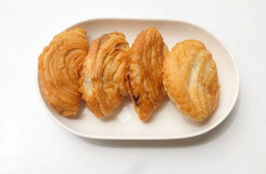 Kızarmış körili börek, körili börek, karipap, epok çağ, beyaz seramik tabakta sarmal körili puf beyaz bir zemin izole etti. Thai körili puf kavramı. Bu pasta Asya 'nın geleneksel atıştırmalıkları. 