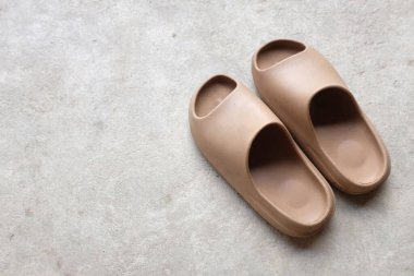 Çimento zeminine izole edilmiş, açık ayak parmağı yastıklı bir çift slayt. Kadın modası. Kadın yaz ayakkabıları, yumuşak terlikler.