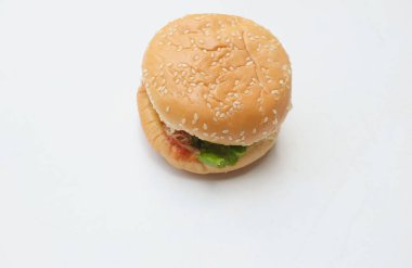 Domuz pirzolası ve domatesli klasik burger. Salatalık, kırmızı soğan, peynir ve marullu susamlı çörek. Beyaz bir arka planda izole edilmiş. Amerikan hamburgeri