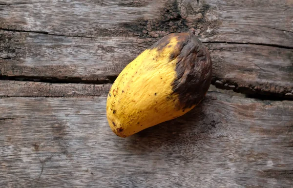 Üst manzara ve düz çürük mango yatıyordu ahşap bir tabakta. Atık gıda kavramı