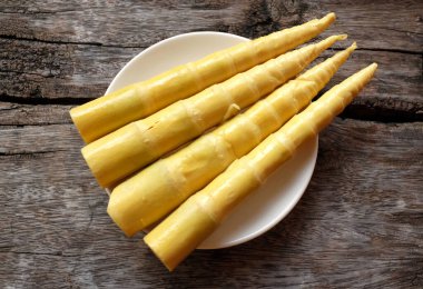 Kaynamış bambu yığını. (Bambusa spp.) Ahşap bir tabakta inwhite plaka fırlatır. Bitkilerden veya sebzelerden besin işleme. Yerel Tayland yemekleri.