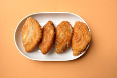 Kızarmış körili börek, körili puf böreği, karipap, epok çağ, spiral körili puf, portakallı pastel bir fon izole etti. Thai körili puf kavramı. Bu pasta Asya 'nın geleneksel atıştırmalıkları.