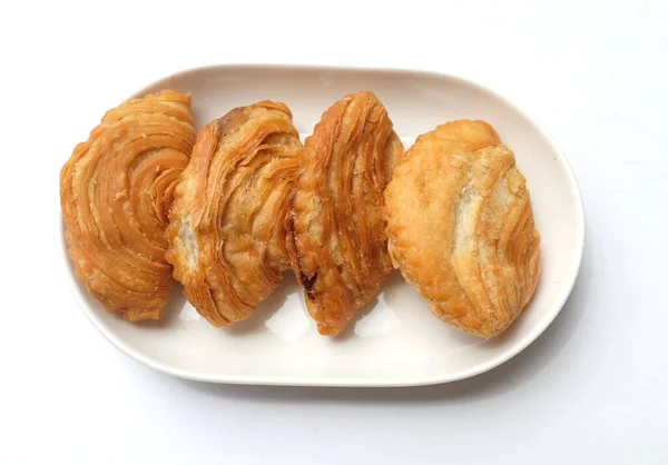 deep fried curry puff,curry puff pastry, karipap,epok epok, spiral curry puff isolated a white backdrop . thai curry puff concept.this pastry is asian traditional snacks