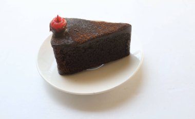 Üst Manzara düz katmanlı koyu çikolatalı pasta bir porsiyon uzanır kırmızı kiraz ile dekore edilmiş beyaz arka plan izolasyonu