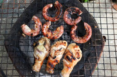 Lezzetli ızgara ince bağırsak, ızgara domuz köftesi, yavaş kömür sobasında kızarmış tavuk Tayland 'da baharat kokusu. Tayland sokak yemeği, iştah açıcı, açık hava yemeği, kamp partisi..