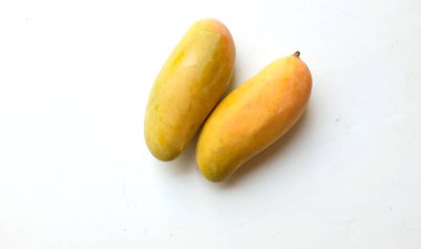  Rengarenk taze mango bir Mahachanok veya Gökkuşağı Mangosu (Mangifera indica L.) beyaz arka planda yalıtılmış yapraklar. Tayland tropikal meyvesi