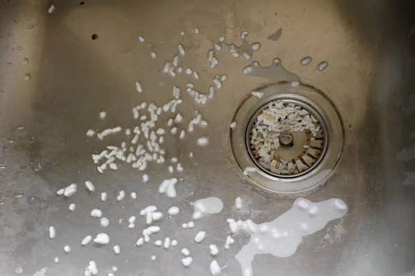 rice waste ,food waste ,kind of garbage,food leftovers  clogging the clogged strainer or metallic silver drain strainer, in  sink ,Food waste. Wastes from after washing dishes