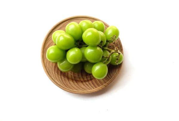 新鮮なスウィートグリーンシャインマスカット ヴィスティーナ のブドウと葉のブドウを白い背景に分離した木製の皿で焼きます 緑のブドウ 日本のブドウ — ストック写真