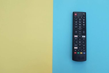 Uzaktan kumandalı televizyon arka plan için iki ton sarı mavi kağıt renginde izole edildi. Metinler için TV izleme kavramı..