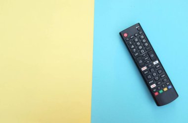 Uzaktan kumandalı televizyon arka plan için iki ton sarı mavi kağıt renginde izole edildi. Metinler için TV izleme kavramı..