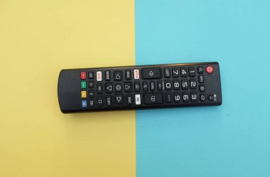 Uzaktan kumandalı televizyon arka plan için iki ton sarı mavi kağıt renginde izole edildi. Metinler için TV izleme kavramı..