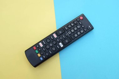 Uzaktan kumandalı televizyon arka plan için iki ton sarı mavi kağıt renginde izole edildi. Metinler için TV izleme kavramı..