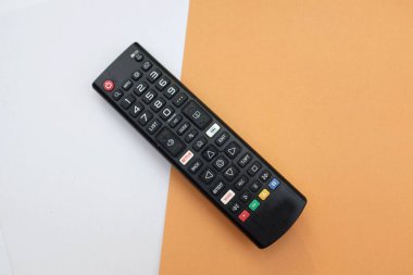 Uzaktan kumandalı televizyon, arka plan için iki ton turuncu beyaz kağıt renginde izole edildi. Metinler için TV izleme kavramı..