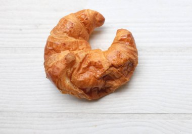 Kahvaltı için Fransız kruvasanı taze pişmiş kruvasan beyaz ahşap masa üzerinde, fotokopi alanı olan üst manzara. Lezzetli bir kahvaltı, lezzetli ve sağlıklı bir başlangıç..