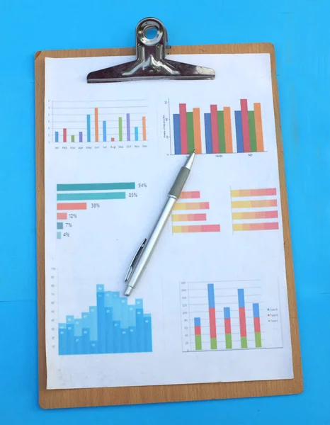 Report paper document Business report chart preparing graphs white pen on blue office desk