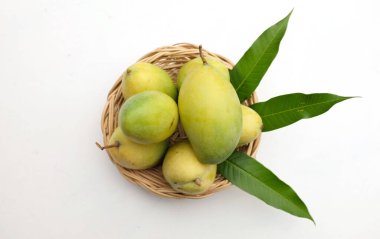 Üst görünüm taze organik (Mangifera Indica L.), zerdeçal mango meyveleri hasır ve beyaz arkaplanda yapraklar. Tayland 'da tropik meyve.