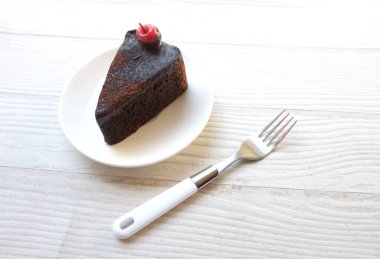 Üst Manzara düz katmanlı koyu çikolatalı pasta bir porsiyon uzanır kırmızı kiraz ile dekore edilmiş beyaz arka plan izolasyonu