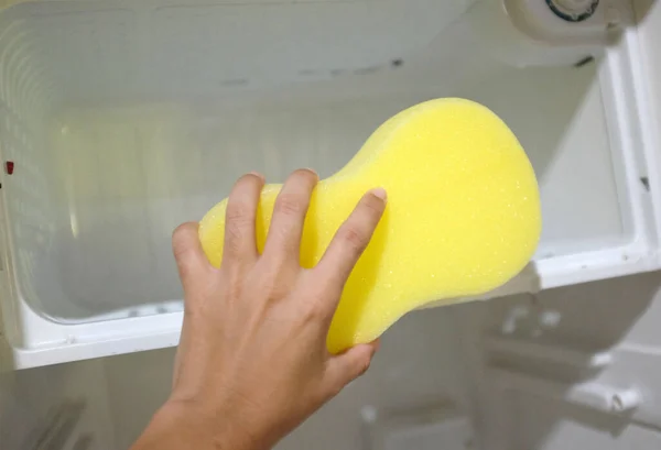 Frau Reicht Einen Gelben Schwamm Reinigt Kühlschrankregale Reinigt Eine Kühlschrankoberfläche — Stockfoto