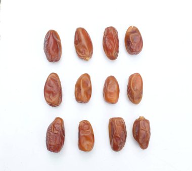 Lezzetli kuru hurma yığınları ya da palmiye ağaçları ya da palmiye anka kuşu dactylifera meyveleri beyaz bir arka planda izole edilir. Atıştırmalık sağlıklı, Arap yemeği, tropikal meyve