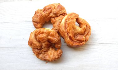 Kahvaltı için Fransız kruvasanı taze pişmiş kruvasan beyaz ahşap masa üzerinde, fotokopi alanı olan üst manzara. Lezzetli bir kahvaltı, lezzetli ve sağlıklı bir başlangıç..