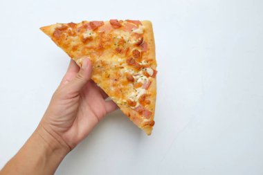 Lezzetli ince bir dilim pizza ananas ve jambonlu, beyaz arka planda seramik bir tabakta peynir (Hawai pizzası). Fast food ve lezzetli parmak atıştırmalığı konsepti için.