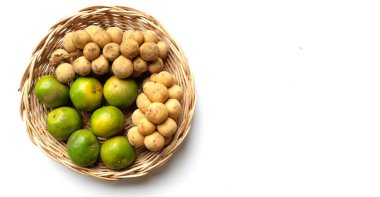 Üst ve düz bir yığın taze tatlı olgun Thai meyvesi portakalı, Tayland 'ın beyaz arka planında izole edilmiş bambu sepetinde yaprağı olan Longkong.