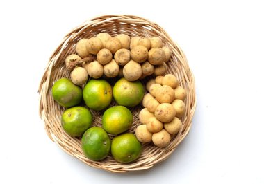 Üst ve düz bir yığın taze tatlı olgun Thai meyvesi portakalı, Tayland 'ın beyaz arka planında izole edilmiş bambu sepetinde yaprağı olan Longkong.