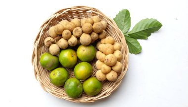 Üst ve düz bir yığın taze tatlı olgun Thai meyvesi portakalı, Tayland 'ın beyaz arka planında izole edilmiş bambu sepetinde yaprağı olan Longkong.