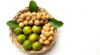 Üst ve düz bir yığın taze tatlı olgun Thai meyvesi portakalı, Tayland 'ın beyaz arka planında izole edilmiş bambu sepetinde yaprağı olan Longkong.