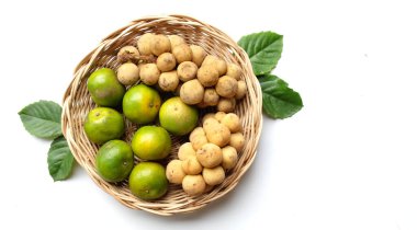 Üst ve düz bir yığın taze tatlı olgun Thai meyvesi portakalı, Tayland 'ın beyaz arka planında izole edilmiş bambu sepetinde yaprağı olan Longkong.