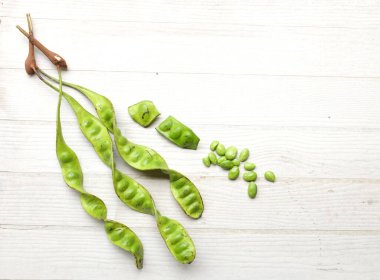 Acı fasulye, bükülmüş fasulye, kokuşmuş fasulye, sato, petai ya da pakria (parkia speciosa), ahşap bir masada yemek pişirmeye hazırlan. Tayland ve Asya 'nın malzemeleri için bitkiler .