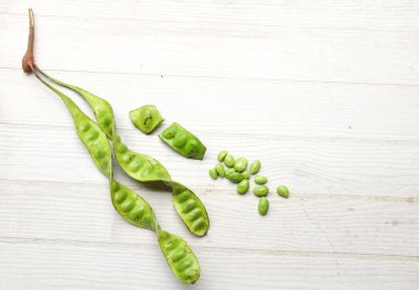 Acı fasulye, bükülmüş fasulye, kokuşmuş fasulye, sato, petai ya da pakria (parkia speciosa), ahşap bir masada yemek pişirmeye hazırlan. Tayland ve Asya 'nın malzemeleri için bitkiler .