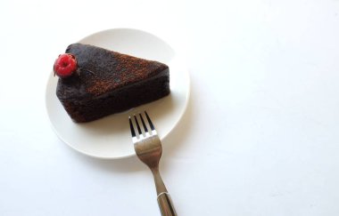 Kırmızı kirazla süslenmiş katmanlı çikolatalı pastanın bir kısmını kopyala. Beyaz arka planda izole edilmiş.