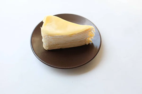 顶部视图和平面放置了一部分分层芝士蛋糕在一个白色的盘子与叉子服务甜点隔离在白色的背景 — 图库照片