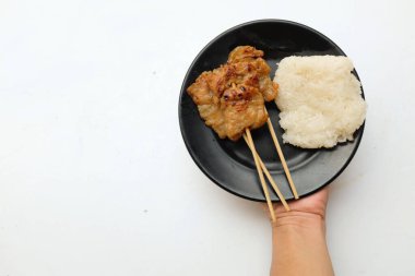 Tabakta pilavlı ızgara domuz eti beyaz bir arka planda yalıtılmış Taylandlılar için kolay yenen bir yemektir. Kahvaltıda meşhurdur..