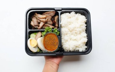 Kızarmış domuz eti, haşlanmış yumurta ve tatlı sosla kaplanmış tatlı. Beyaz bir arka planda izole edilmiş. Tayland yemeği. Kutu sette kızartılmış biftek.