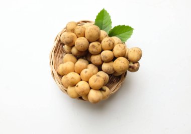 kopyalama alanı taze organik (lansium domesticum corr.) Longkong langsat meyvesi. Beyaz arka planda hasır sepette yaprak var. Tayland 'da tropik meyve. Sağlıklı meyve.