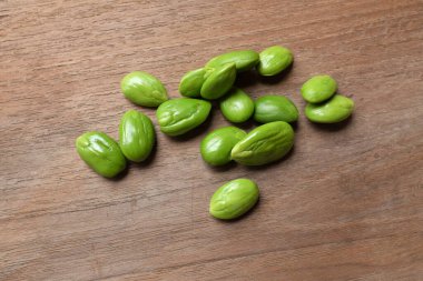 Acı fasulye, bükülmüş fasulye, kokuşmuş fasulye, sato, petai ya da pakria (parkia speciosa), ahşap bir masada yemek pişirmeye hazırlan. Tayland ve Asya 'nın malzemeleri için bitkiler 