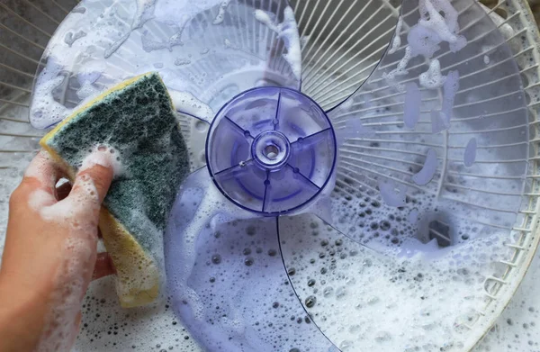 stock image close up a asian young woman disassembles the fan full of dust to clean the bring an electric fan to wash the water. scrub with detergent. housework cleaning concept