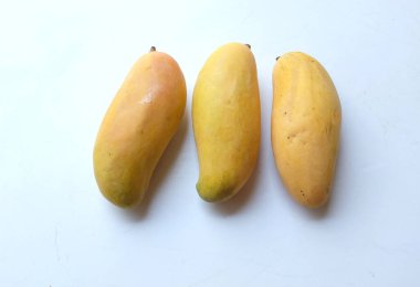 Hasır sepetinde yaprakları olan iştah açıcı sarı mango. Beyaz arka planda izole edilmiş. Tayland 'ın sağlıklı meyvesi.