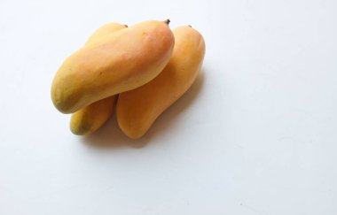 İştah açıcı sarı mango Mahachanok Mango (Mangifera indica L) hasır sepetin içinde beyaz arka planda izole edilmiş yapraklar. Tayland 'ın sağlıklı meyvesi. Yaz meyvesi.